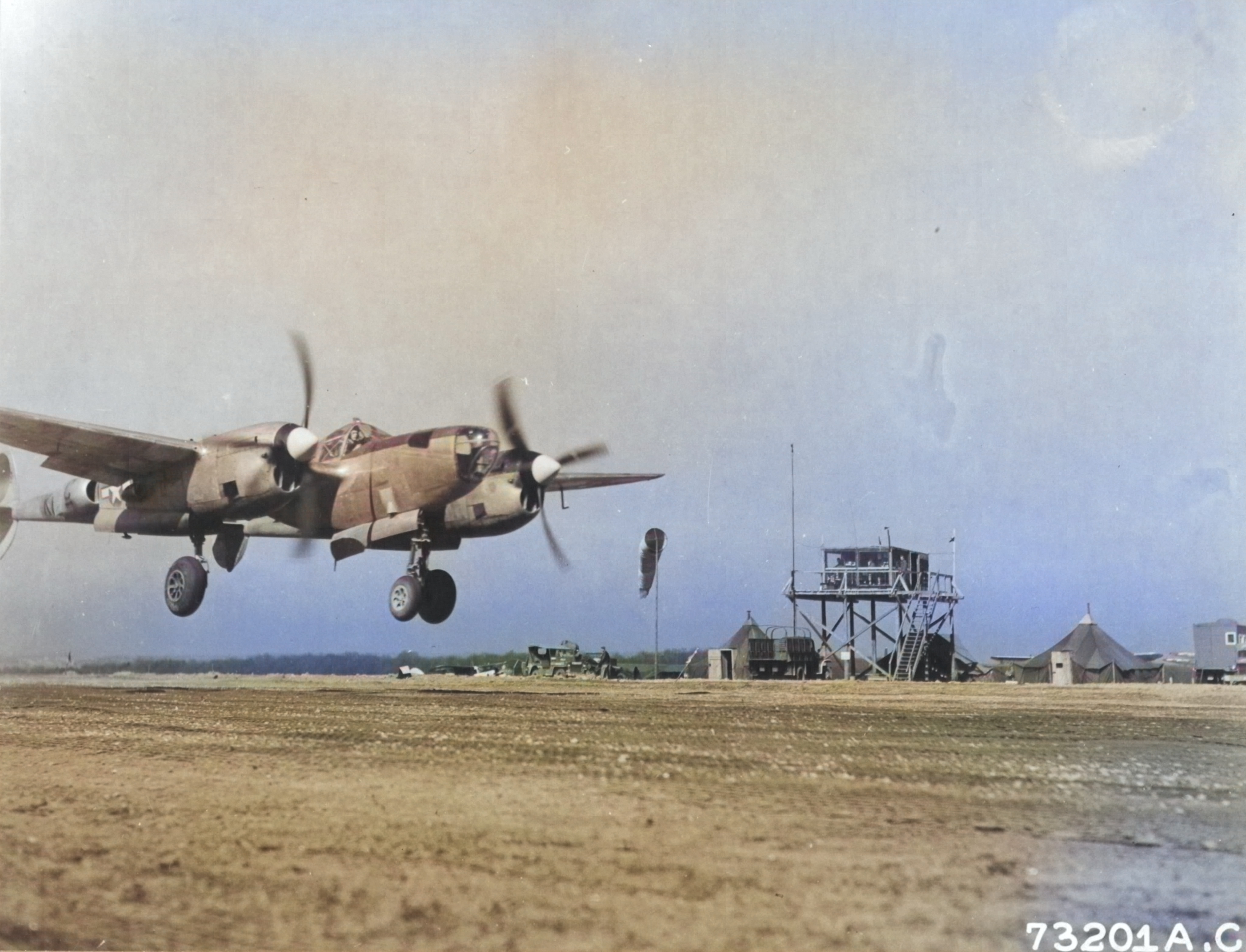 P-38J Lightning Droop Snoot with the 402nd Fighter Squadron coming in for a landing, possibly at Sandweiler, Luxembourg, Apr 10 1945. [Colorized by WW2DB]