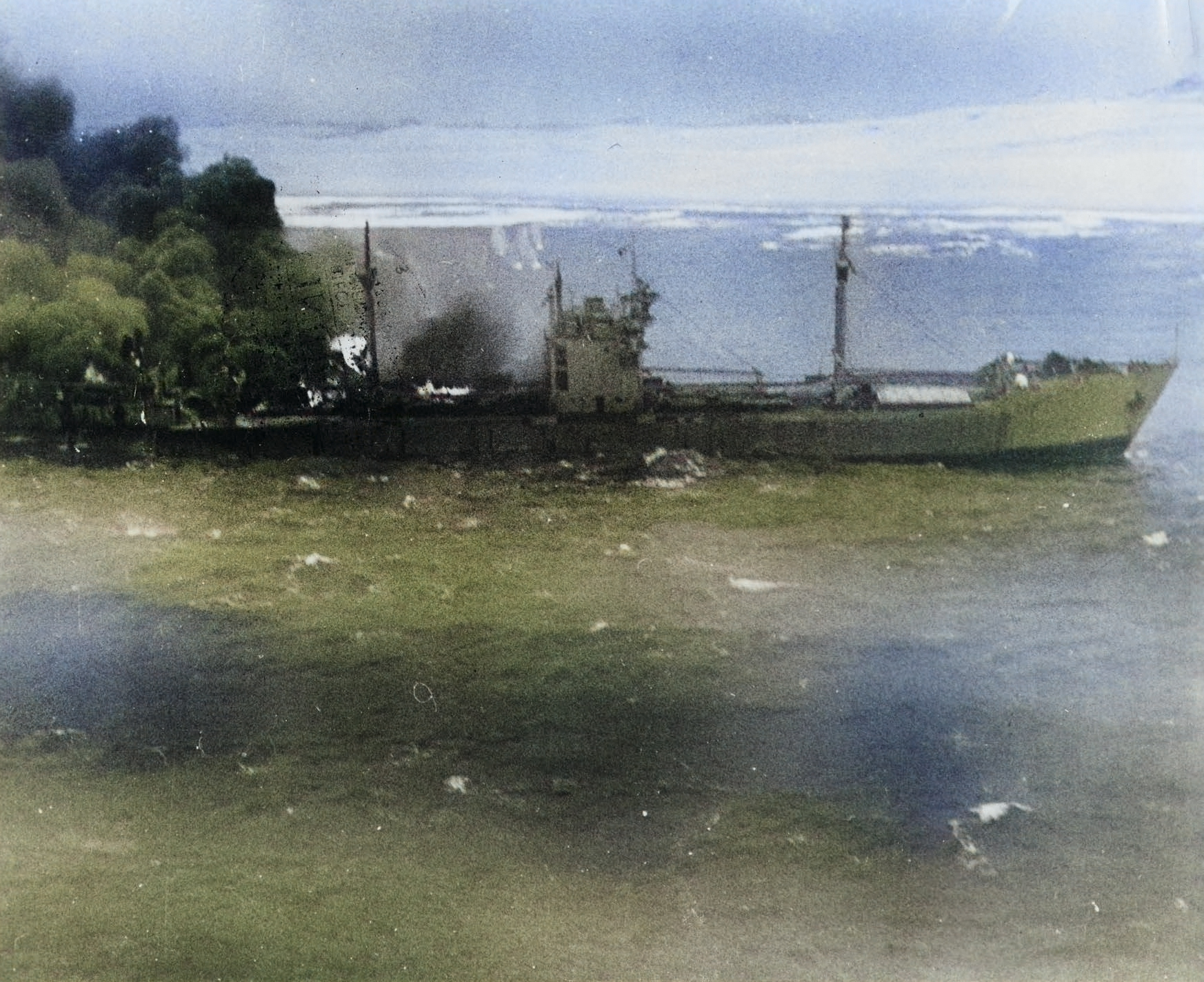 Japanese Type 2AT tanker Otsusan Maru burning and heading for the beach on the coast of French Indochina (Vietnam) north of Qui Nhon after its convoy was attacked by 175 United States Navy carrier planes, Jan 12, 1945. [Colorized by WW2DB]