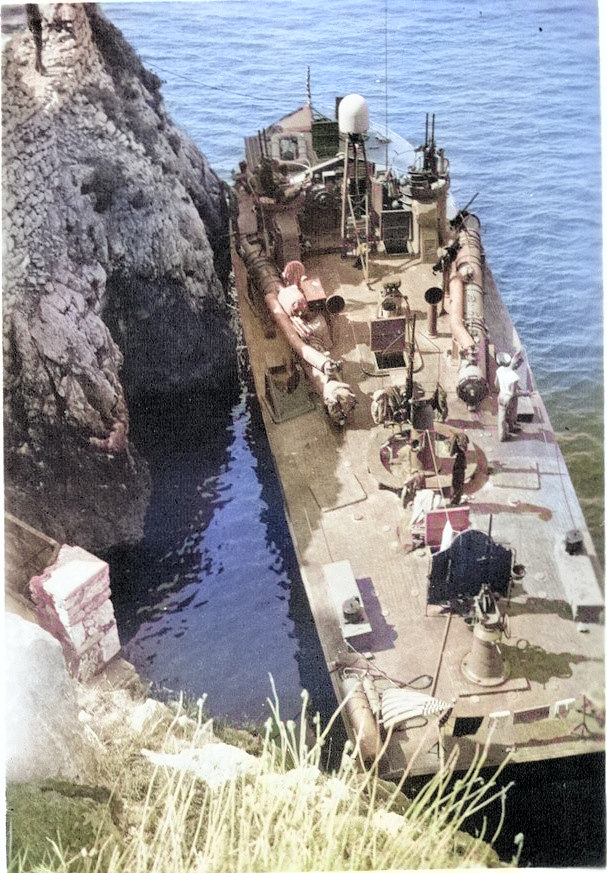 PT-215, a Higgins 78-footer of Motor Torpedo Boat Squadron 15 (MTBRon 15), tied up in Blue Grotto, Capri, Italy in Mar 1944. [Colorized by WW2DB]