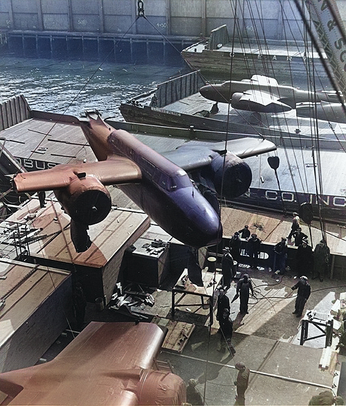 A section of the A-20 Havoc bomber being loaded onto a transport ship, 1943 [Colorized by WW2DB]