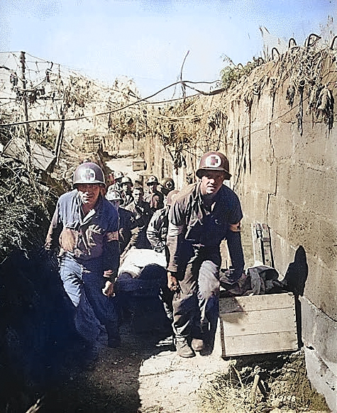 US Army medics removing a casualty from the battlefield to an aid station in an air shelter, near Brest, France, 28 Aug 1944 [Colorized by WW2DB]