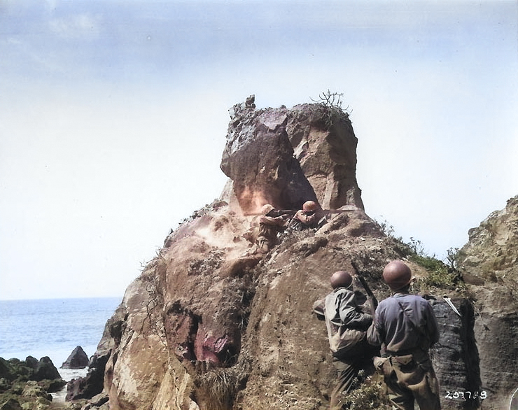 Americans attacked Japanese snipers in a cave with bazooka and small arms, northern coast of Iwo Jima, during mop up operations, 8 Apr 1945 [Colorized by WW2DB]