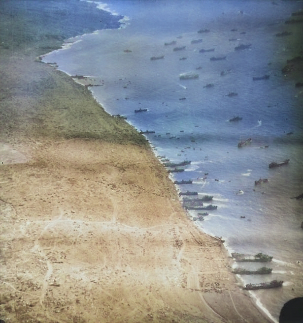 Aerial photograph of Iwo Jima's east landing beaches as LSTs, LSMs, and LCTs unloaded supplies, circa late Feb 1945 [Colorized by WW2DB]