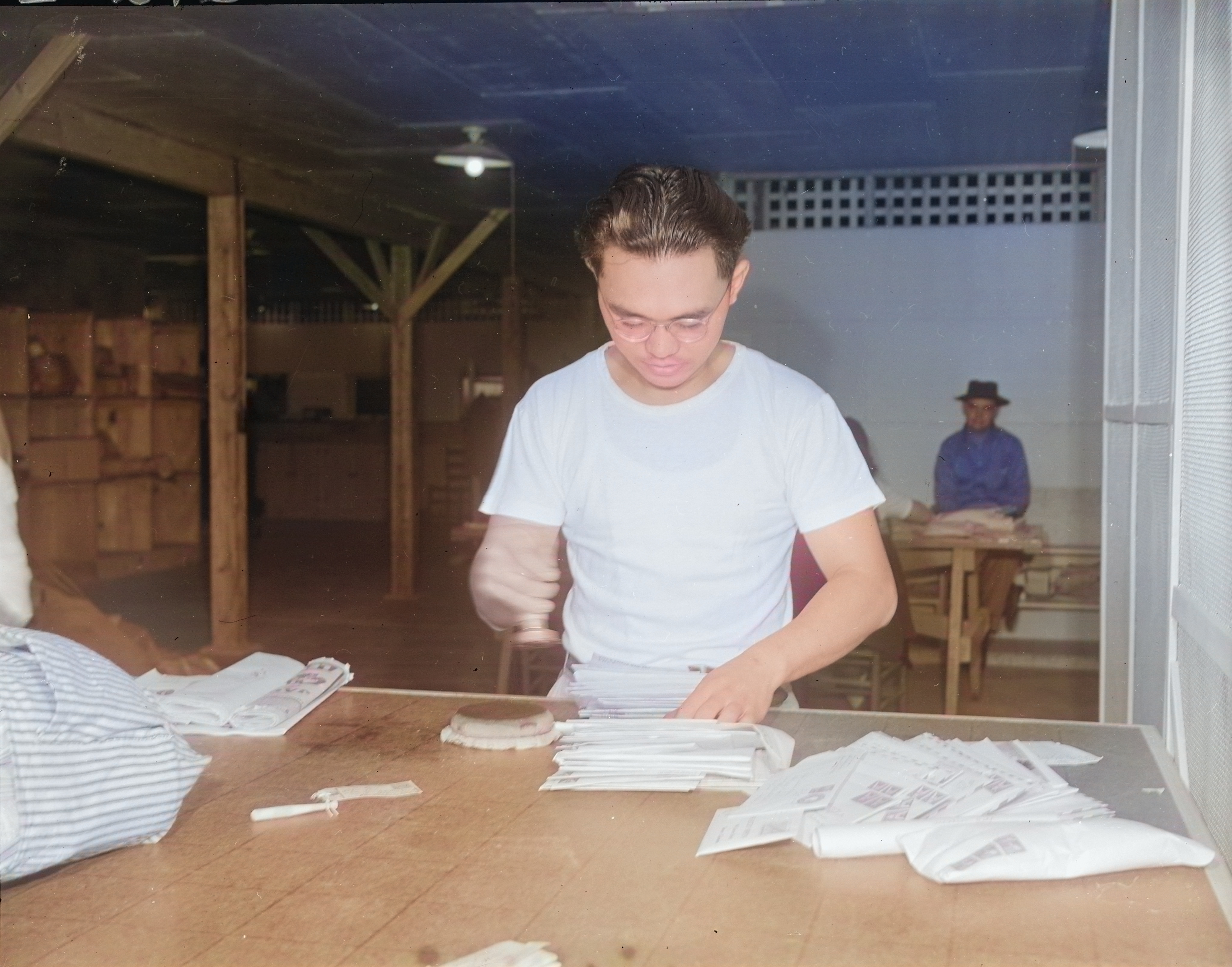 Chief Postal Orderly Masaki Hironoka at work at the post office at Jerome War Relocation Center, Arkansas, United States, 20 Nov 1942 [Colorized by WW2DB]