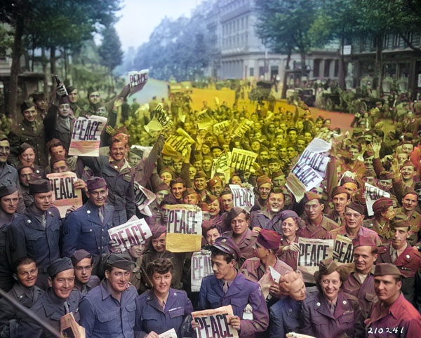 American servicemen and women gathered in front of 'Rainbow Corner' Red Cross club in Paris, France to celebrate the unconditional surrender of the Japanese, 15 Aug 1945 [Colorized by WW2DB]