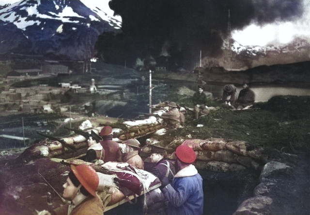 US Marines in a trench at Dutch Harbor, US Territory of Alaska, 3 Jun 1942; note burning fuel tanks in background [Colorized by WW2DB]