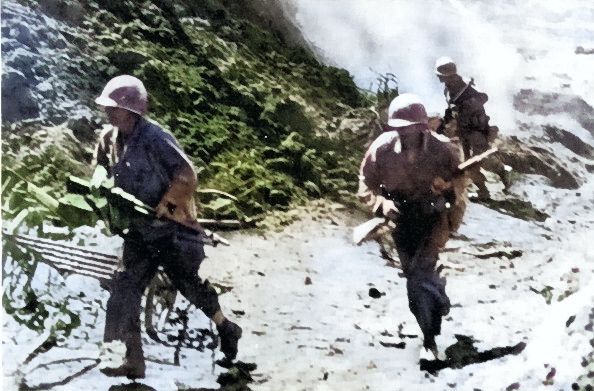 US corkscrew demolition team at Okinawa, Japan, circa Apr-Jun 1945; note cave blast in background [Colorized by WW2DB]