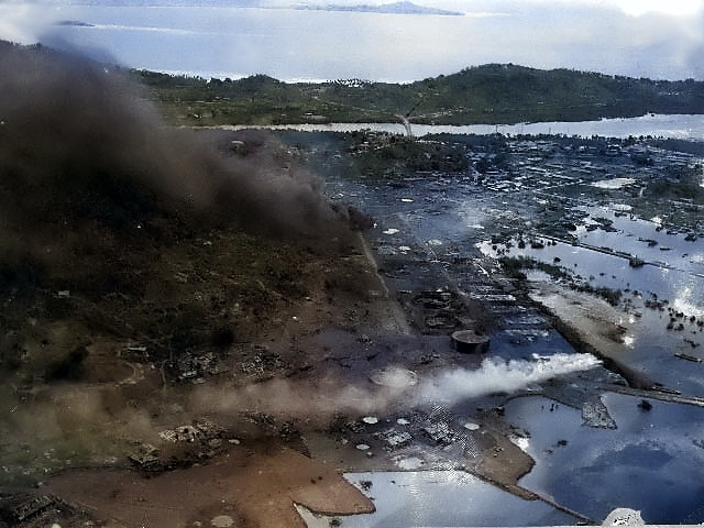 Aerial photo showing damage done to Japanese naval base at Dublon Island, Truk Atoll, Caroline Islands, 17-18 Feb 1944 [Colorized by WW2DB]