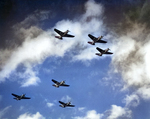 Navy Bombing Squadron 11 performing a formation fly-by in their SB2C Helldivers over their carrier, the USS Hornet (Essex-class), 1944.