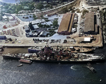 United States battleship USS Wisconsin at the Pearl Harbor Naval Base tying up alongside the hulk of the battleship Oklahoma, which had been decommissioned just two months earlier, 11 Nov 1944.