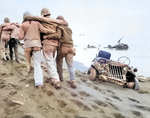 Navy corpsmen helped a wounded Marine to reach an aid station, Iwo Jima, Feb-Mar 1945. Note crushed Jeep and submerged M4 Sherman tank.