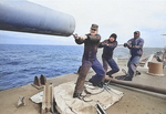 Crewmen of USS Canberra cleaning one of the cruiser