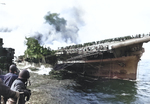 Franklin listing and afire after being hit by two bombs, off Japan, 19 Mar 1945; photograph taken from cruiser Santa Fe