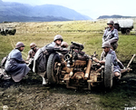 US Army gun crew preparing to fire a 37mm sub-caliber mounted on a 75mm field howitzer during range practice, Sanskeid Range, Iceland, 20 Jun 1943; note M8 carriage