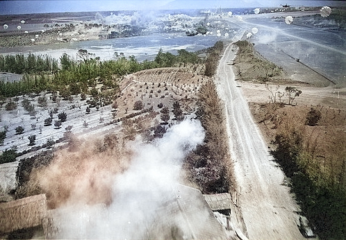 US bombers attacking Lamsepo Airfield with parafrag bombs, Linkou, Taiwan, 14 Apr 1945, photo 2 of 3 [Colorized by WW2DB]