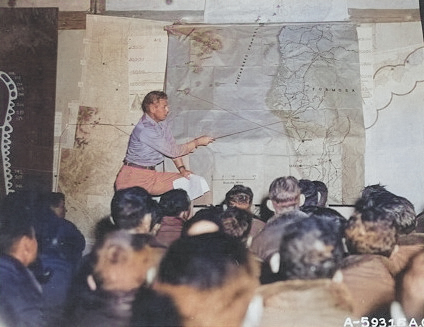 Major Louis E. Scherck briefing airmen of 40th Bomb Group, USAAF XX Bomber Command at a base in China, 14 Oct 1944; note map of Taiwan showing Takao region [Colorized by WW2DB]