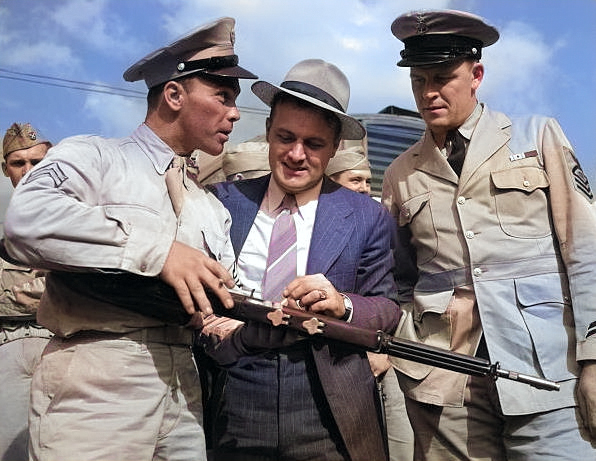 US Army Sergeant Vineyard showing his rifle to civilian welder George Woolslayer and US Navy enlisted man John Evans at Allegheny-Ludlum Steel, Pittsburgh, Pennsylvania, United States, Aug 1942 [Colorized by WW2DB]