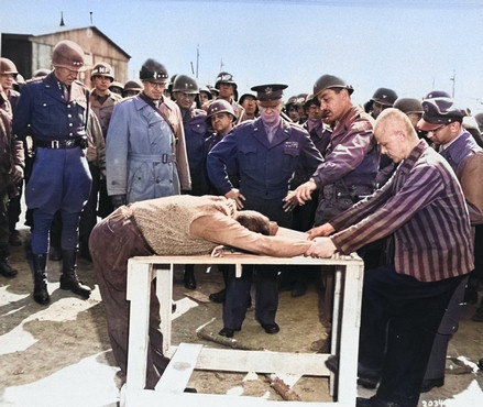 Survivors of Ohrdruf Concentration Camp demonstrating a method of torture they were subjected, Thuringia, Germany, 12 Apr 1945; Alois Liethe (mustached) was interpretor to Eisenhower [Colorized by WW2DB]