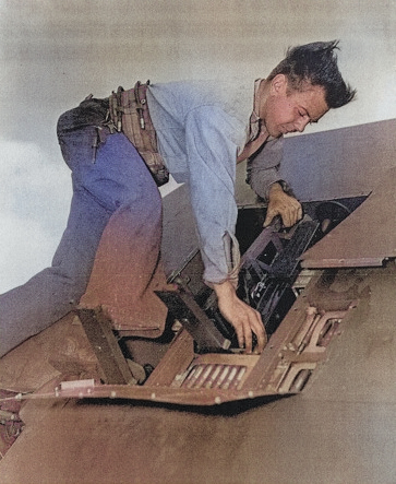 Aviation Ordnanceman 1st Class Billy Simms inspecting the wing guns of a fighter aircraft aboard USS Anzio, 18 Apr 1945 [Colorized by WW2DB]