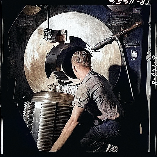 Sailor of American battleship New Jersey lowering the breech block of one of the ship's 16-in guns in preparation of loading a shell, Nov 1944 [Colorized by WW2DB]