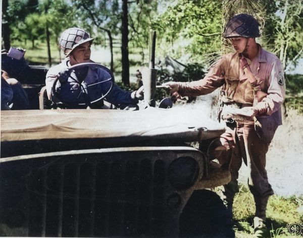 Japanese-American sergeant of US 442nd Regimental Combat Team delivering mail to a Jeep driver, date unknown [Colorized by WW2DB]