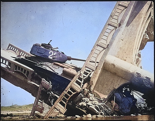 Wreckage of a North Korean T-34/85 medium tank on a bombed out bridge, south of Suwon, Korea, 7 Oct 1950 [Colorized by WW2DB]