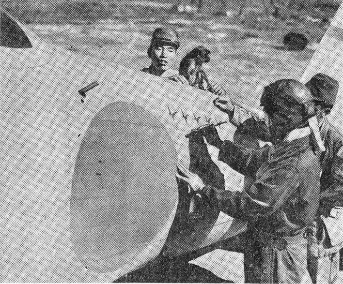 A Japanese pilot marking a victory on his A6M Zero fighter, 14 Feb 1942; note his unit's mascot, a monkey, on the aircraft