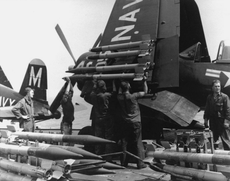 Armorers equipping a F4U-4B Corsair fighter of US Navy squadron VF-64 with Ram and HVAR rockets aboard USS Philippine Sea, off Korea, 21 May 1951