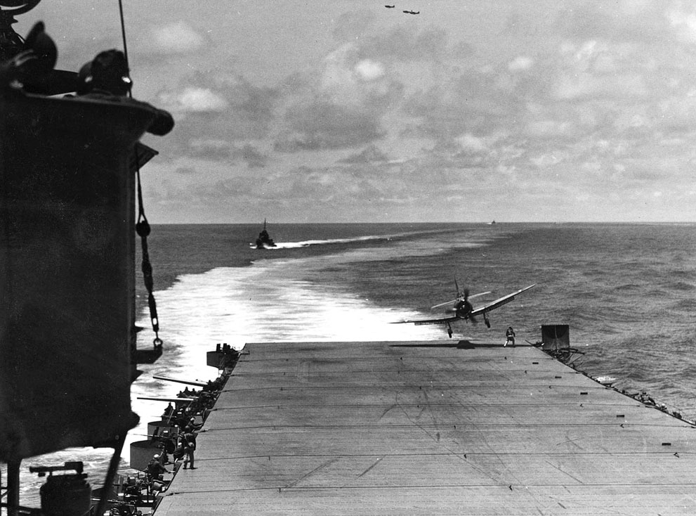 SBD Dauntless aircraft landing aboard USS Hornet during the Battle of Midway, 4 Jun 1942; note Landing Signal Officer undernearth the landing aircraft