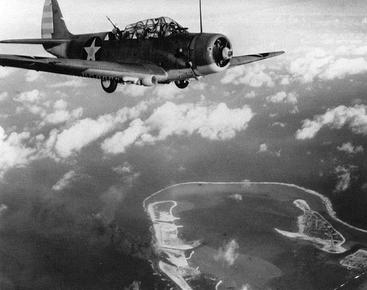 A TBD-1 Devastator bomber flew over Wake Island during the American attack of 24 Feb 1942; note thick smoke in lower center