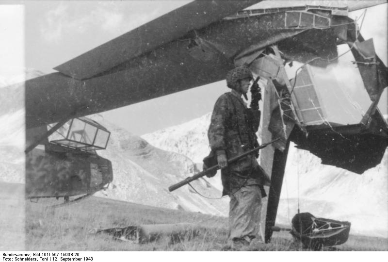 A German glider trooper next to a DFS 230 C-1 glider damaged during landing, Gran Sasso, Italy, 12 Sep 1943