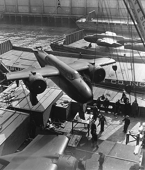 A section of the A-20 Havoc bomber being loaded onto a transport ship, 1943