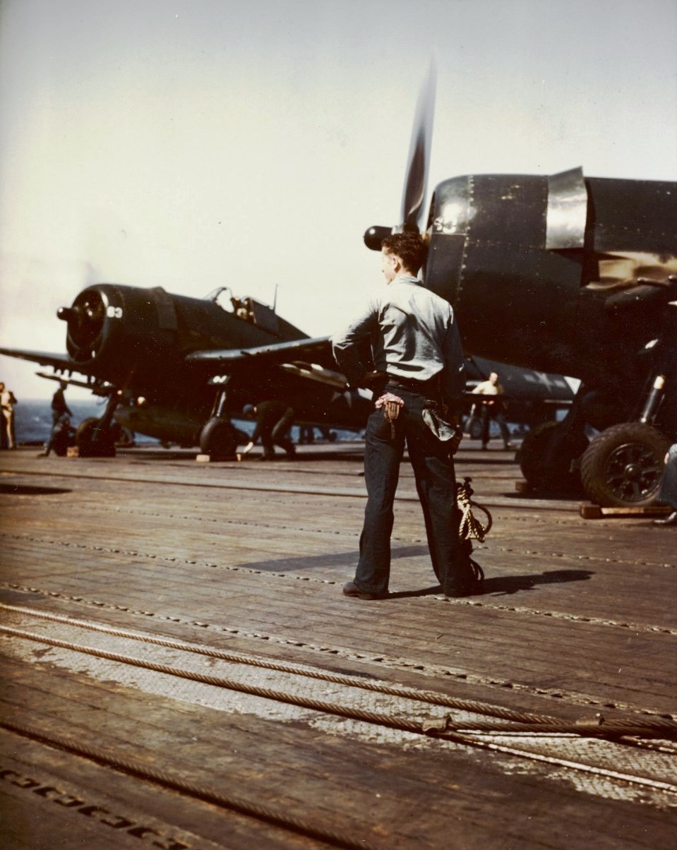 US Navy VF-82 F6F-5 Hellcat fighter ready for launch from USS Bennington, off Okinawa, May 1945; note the fighter's captain in foreground