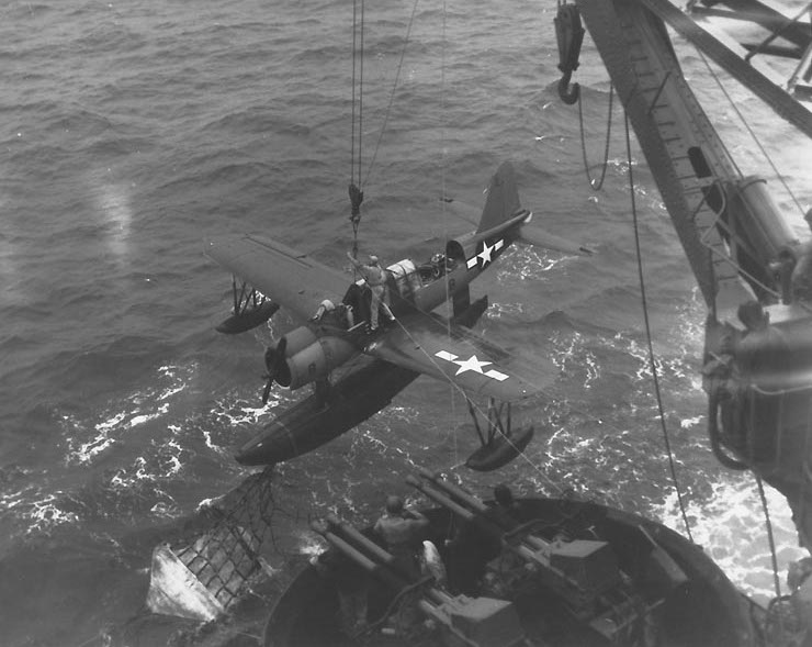 OS2U Kingfisher aircraft being recovered by battleship USS Texas, off Iwo Jima, at 1700 on 16 Feb 1945; note netting of recovery sled hooked on pontoon’s recovery hook