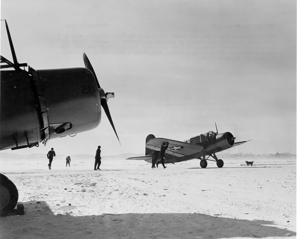 US Navy OS2U Kingfisher aircraft immediately after landing in snow after a scouting mission in the North Atlantic, 2 Feb 1943; note squadron canine mascot 'Slipstream' at right