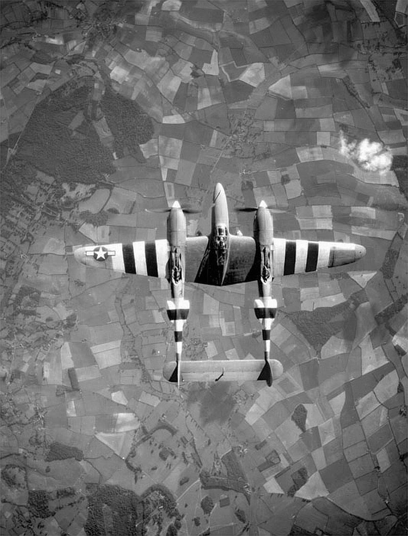 Top view of a P-38 Lightning aircraft in flight over the English countryside, Jun 1944