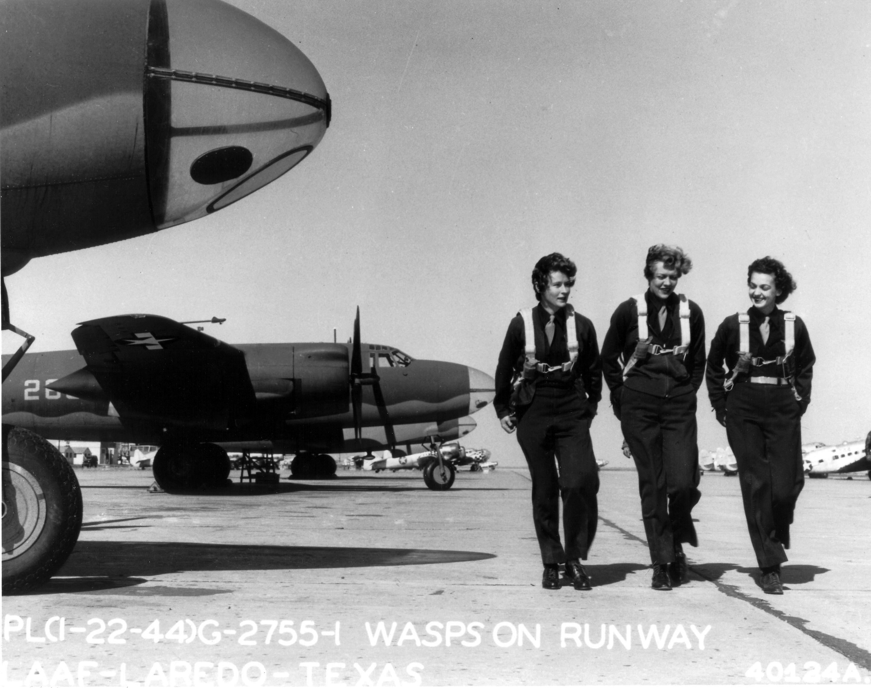 WASP pilots at Laredo Army Air Force Base, Texas, United States, 22 Jan 1944; note B-26 Marauder, AT-6 Texan, and C-56 Lodestar aircraft in background