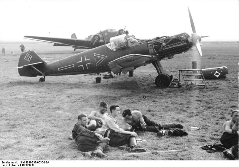 German Luftwaffe crew relaxing on an airfield, 1939-1940; note Bf 109 fighter of JG 53 'Pik As' fighter wing and Ju 52 aircraft in background