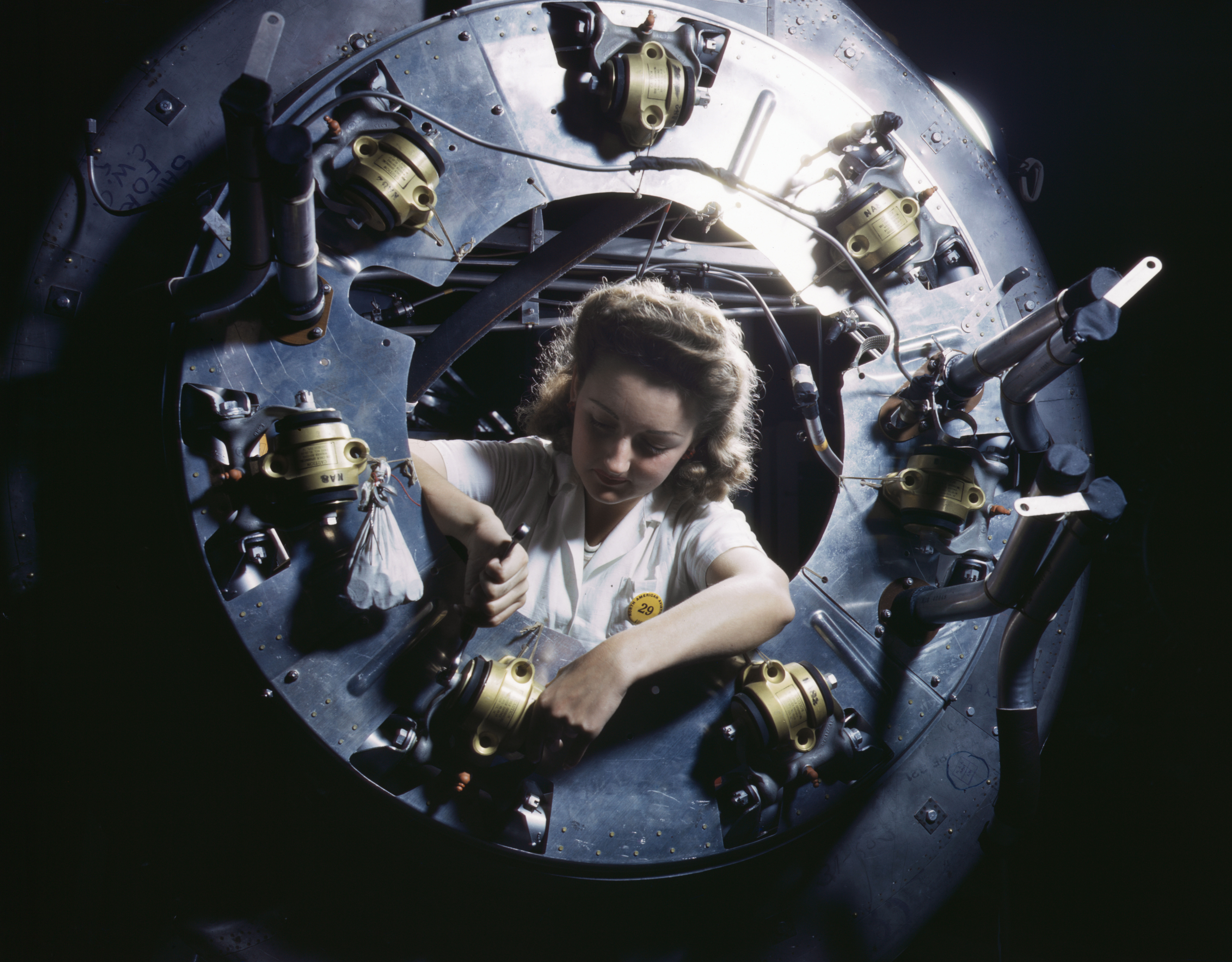 Female worker of North American Aviation working on the cowling of an engine for a B-25 Mitchell bomber, Inglewood, California, United States, Oct 1942