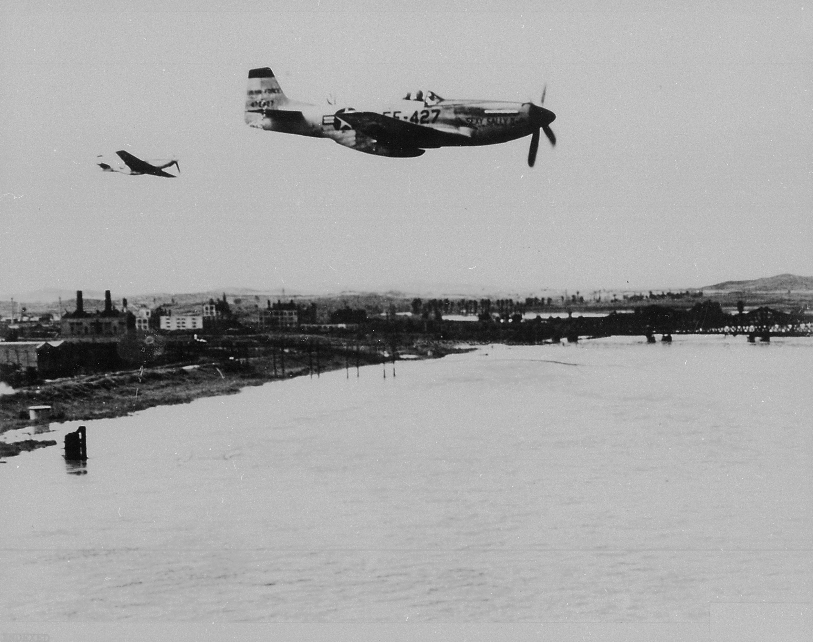F-51 Mustang fighters of US 18th Fighter Bomber Wing crossing over a river in North Korea, Aug 1951
