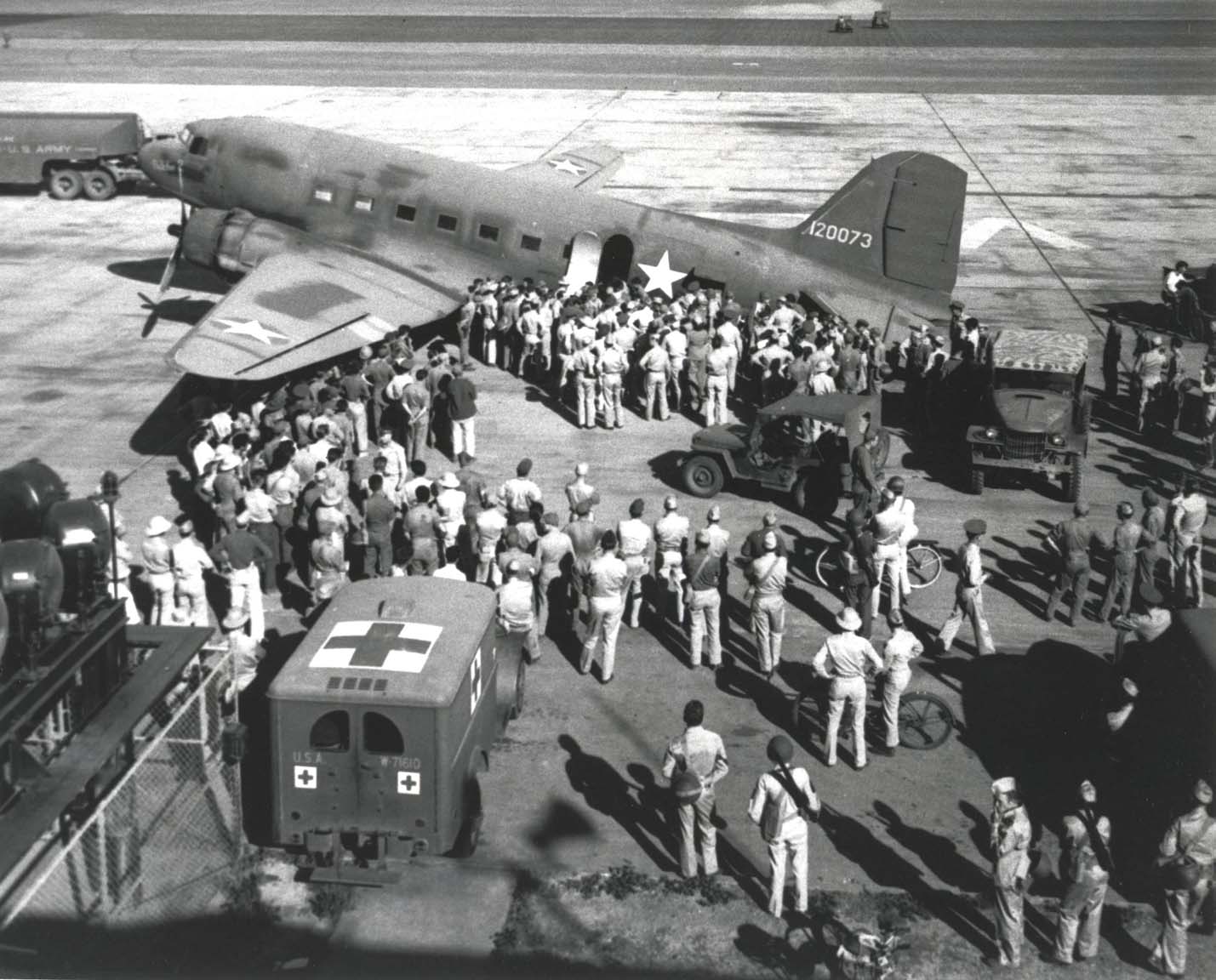 Wounded from Battle of Midway being offloaded from a C-53 variant of C-47 aircraft at Hickam Field, Oahu, US Territory of Hawaii, 7 Jun 1942; note Jeep and WC-9 ambulance