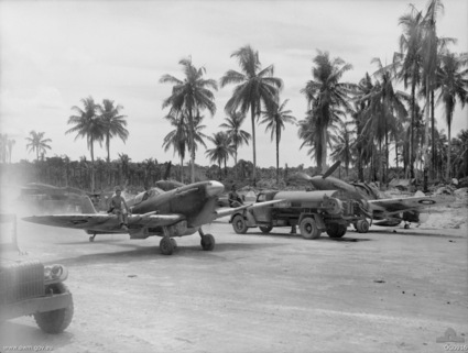 Two No. 79 Squadron RAAF Spitfire aircraft and ground crew at Momote Airfield, Los Negros Island, Admiralty Islands, circa Apr 1944