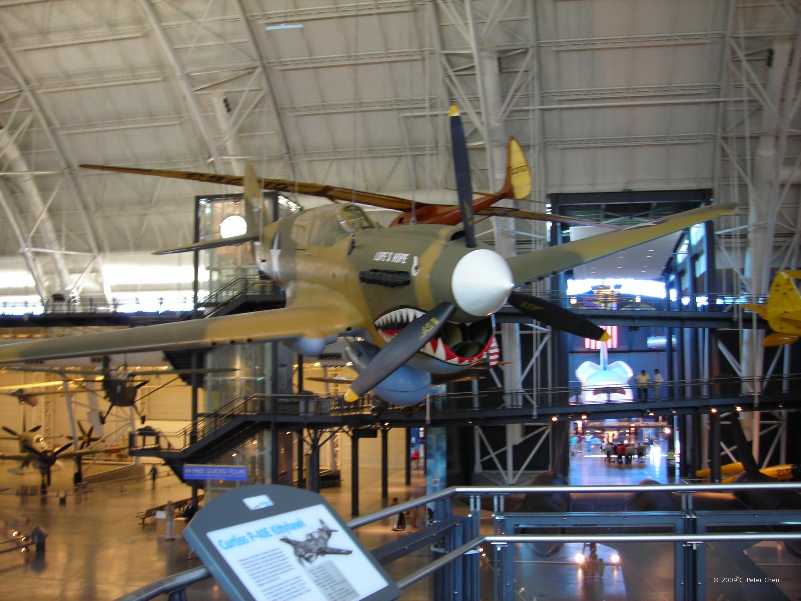 P-40E Warhawk fighter on display at Smithsonian Air and Space Museum Udvar-Hazy Center, Chantilly, Virginia, United States, 26 Apr 2009; note L-5 Sentinel and Do 335 Pfeil aircraft in background