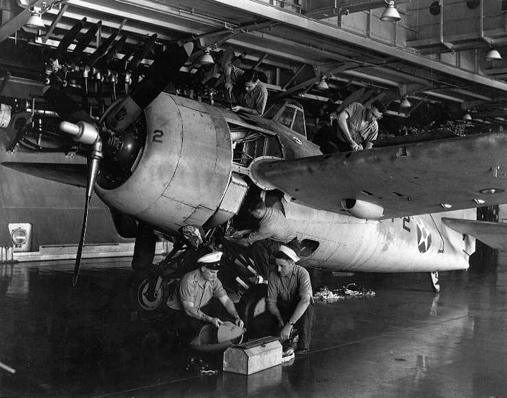 F4F-3 Wildcat undergoing maintenance in USS Enterprise's hangar deck, 28 Oct 1941; note spare propellers hanging overhead