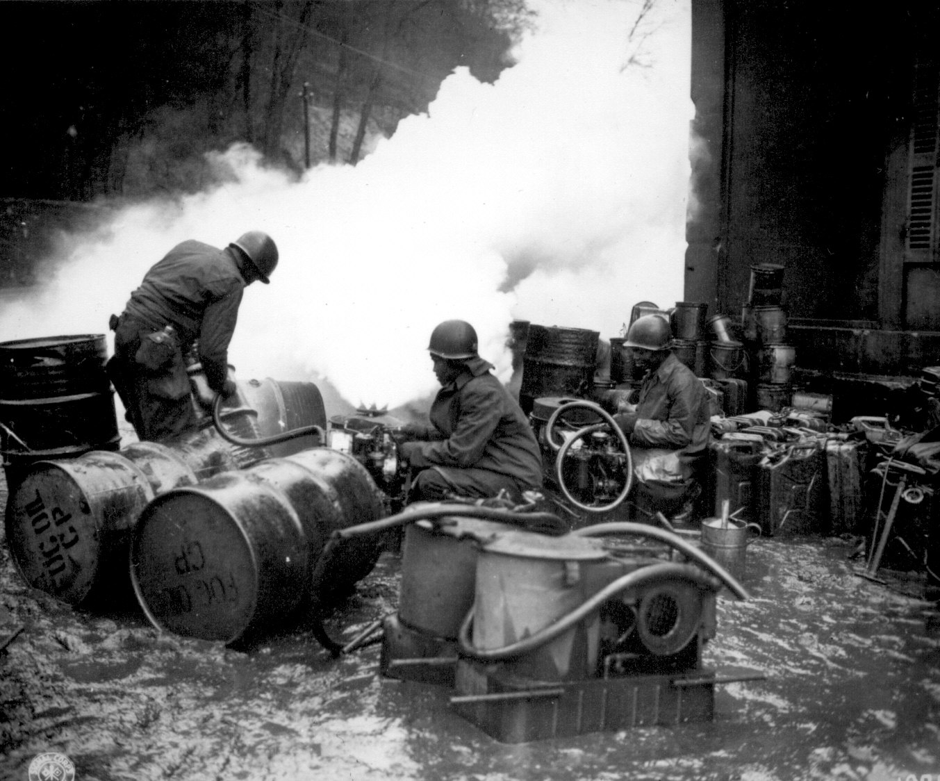 African-American soldiers of the 161st Chemical Smoke Generating Company of the US 3rd Army refilling a M-2 smoke generator, at the Saar River near Wallerfangen, Germany, 11 Dec 1944