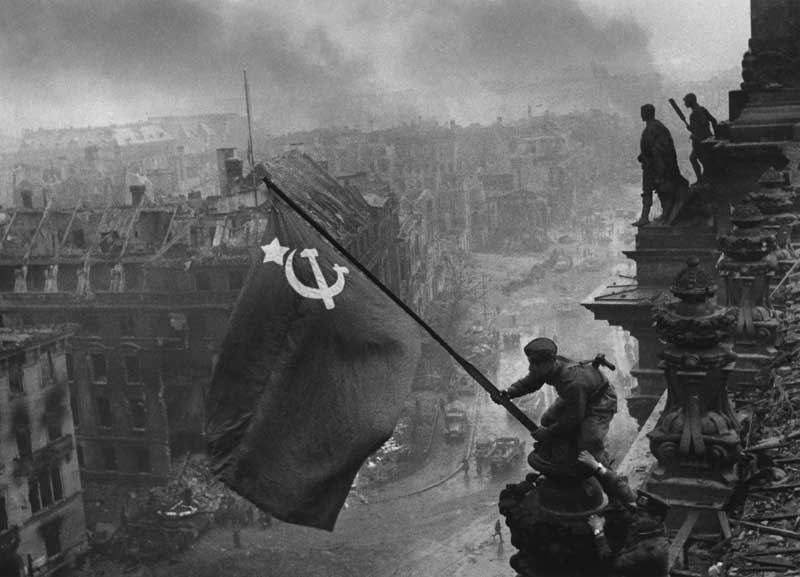 Red Army soldier Mikhail Alekseevich Yegorov of Soviet 756 Rifle Regiment flying the Soviet flag over the Reichstag, Berlin, Germany, 2 May 1945, photo 1 of 3