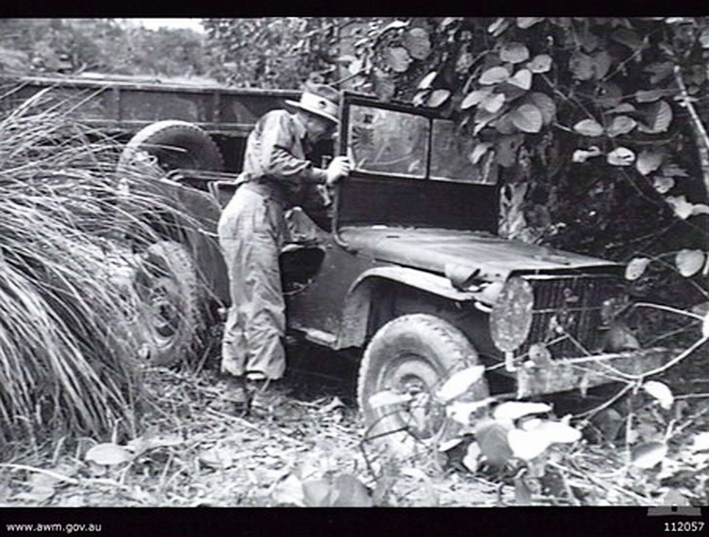 Australian Army Lieutenant MG Searles, 2/25 infantry battalion, inspecting a Japanese Jeep found abandoned on the Milford highway near Popes Track, Balikpapan area, Borneo, 22 Jul 1945