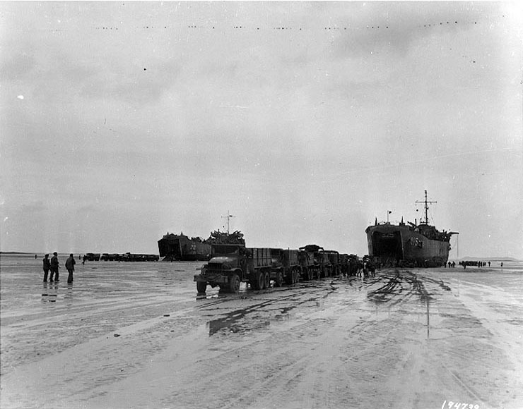 LST-72 and LST-325 unloading directly onto trucks after being left 'high and dry' by the tide at Morlaix, France, 5 Sep 1944