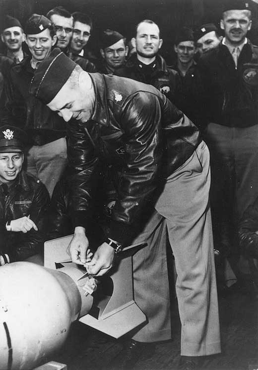 Doolittle wiring a Japanese medal to a bomb, Apr 1942, 1 of 2