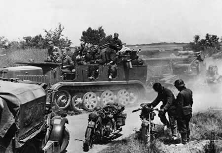 A Flak 18 gun and its crew in Belgium, May 1940; note British Morris C8 tractor and German BMW R18 and DKW NZ350 motorcycles in foreground